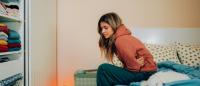 woman sitting on the bed in pain
